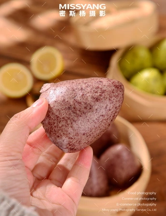 一只手在一碗水果前抓着一个土豆