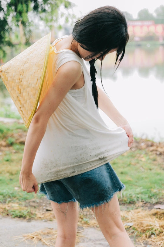 一位身穿蓝色衣服、打着黄色雨伞的年轻女子