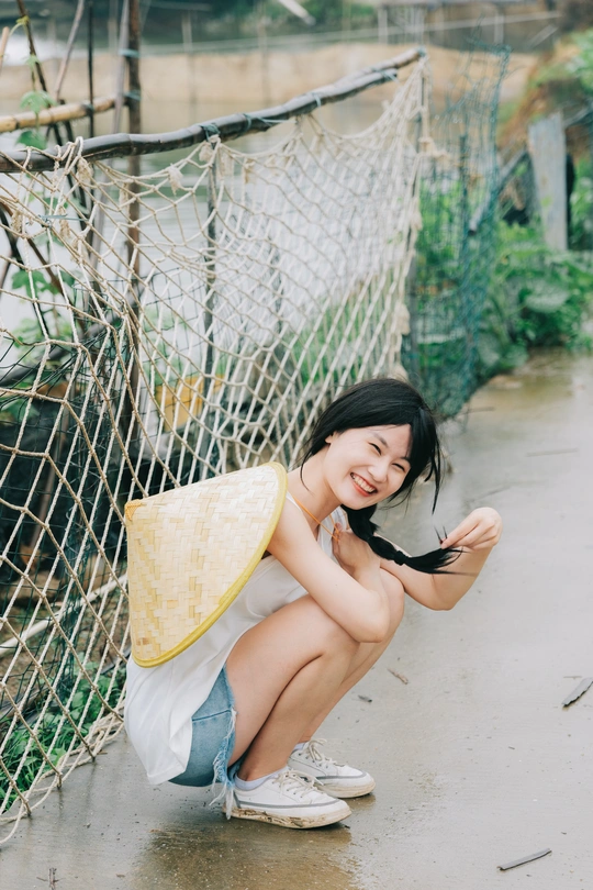 一名年轻女子在雨中撑着伞在网前摆姿势