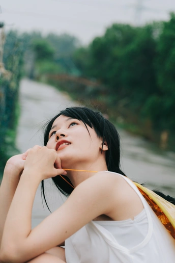 一个穿着连衣裙的年轻女子坐在河边