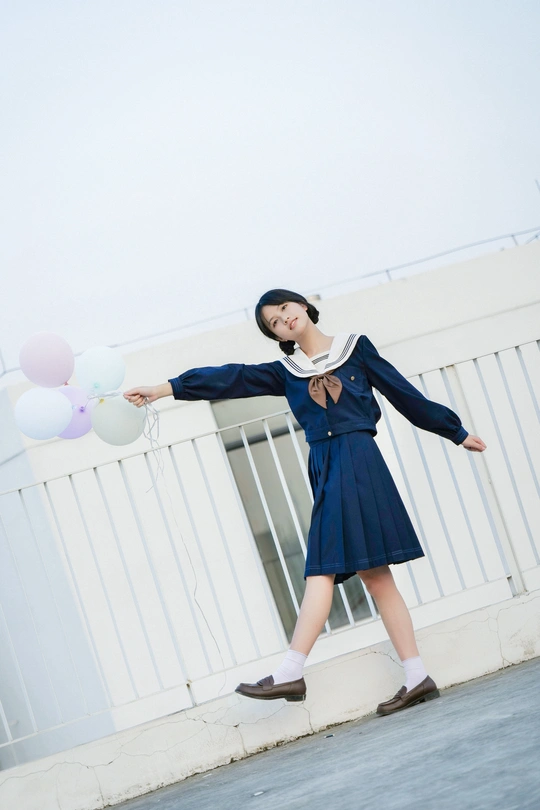 一个穿着蓝色制服的年轻女子手里拿着白色气球