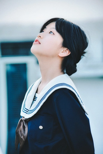 一个黑头发、穿着黑色夹克的年轻女子抬头仰望天空