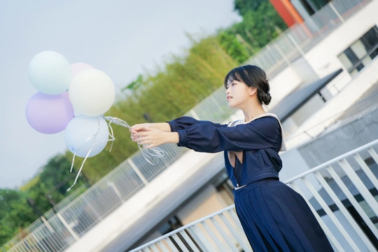 一个穿着蓝色连衣裙的年轻女子手里拿着白色气球