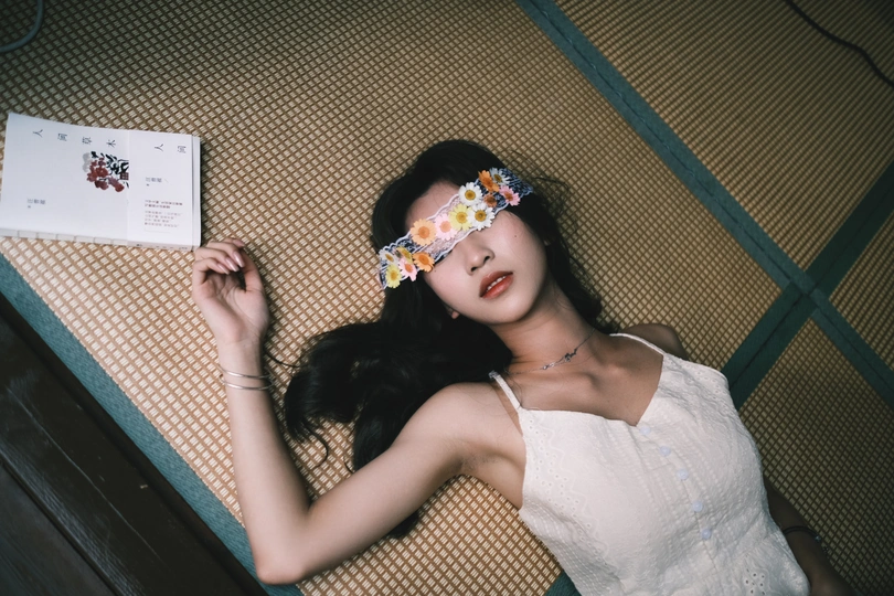 一个年轻女子穿着白色连衣裙躺在床上 头发在后面