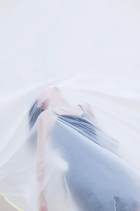 模糊不清的女士穿着白色连衣裙 手里拿着蓝色雨伞