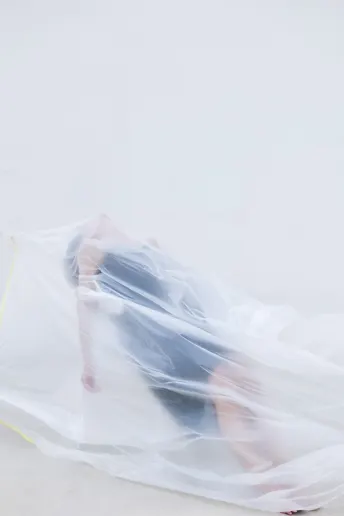 一个穿着白色连衣裙 带着塑料雨伞在地面上的女人