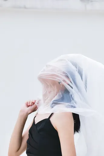 一位穿着黑色连衣裙和白色面纱的女士