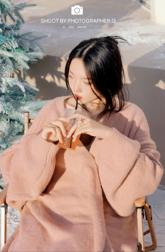 一个穿粉红色衣服的女人正在用杯子喝水
