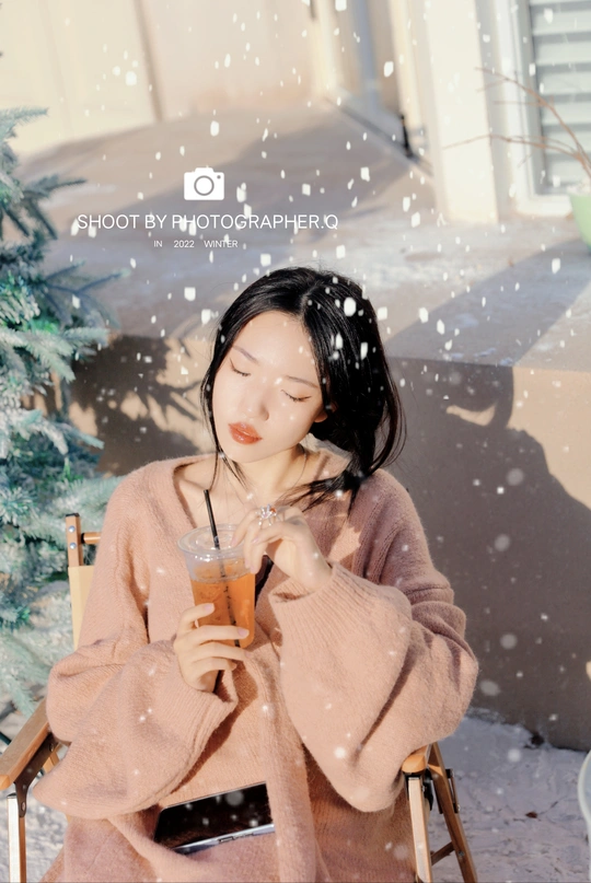 一个女孩在雪地里喝饮料
