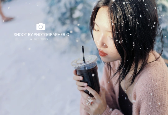 一张年轻女子在雪地里喝咖啡的照片