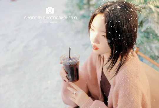 冬天在雪地里喝咖啡的女人