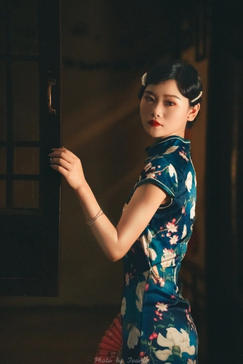 一个穿着蓝色和服的年轻女子在门前抱着一个娃娃