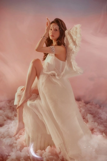 一个穿着带翅膀的白色连衣裙的美女在天空中摆姿势