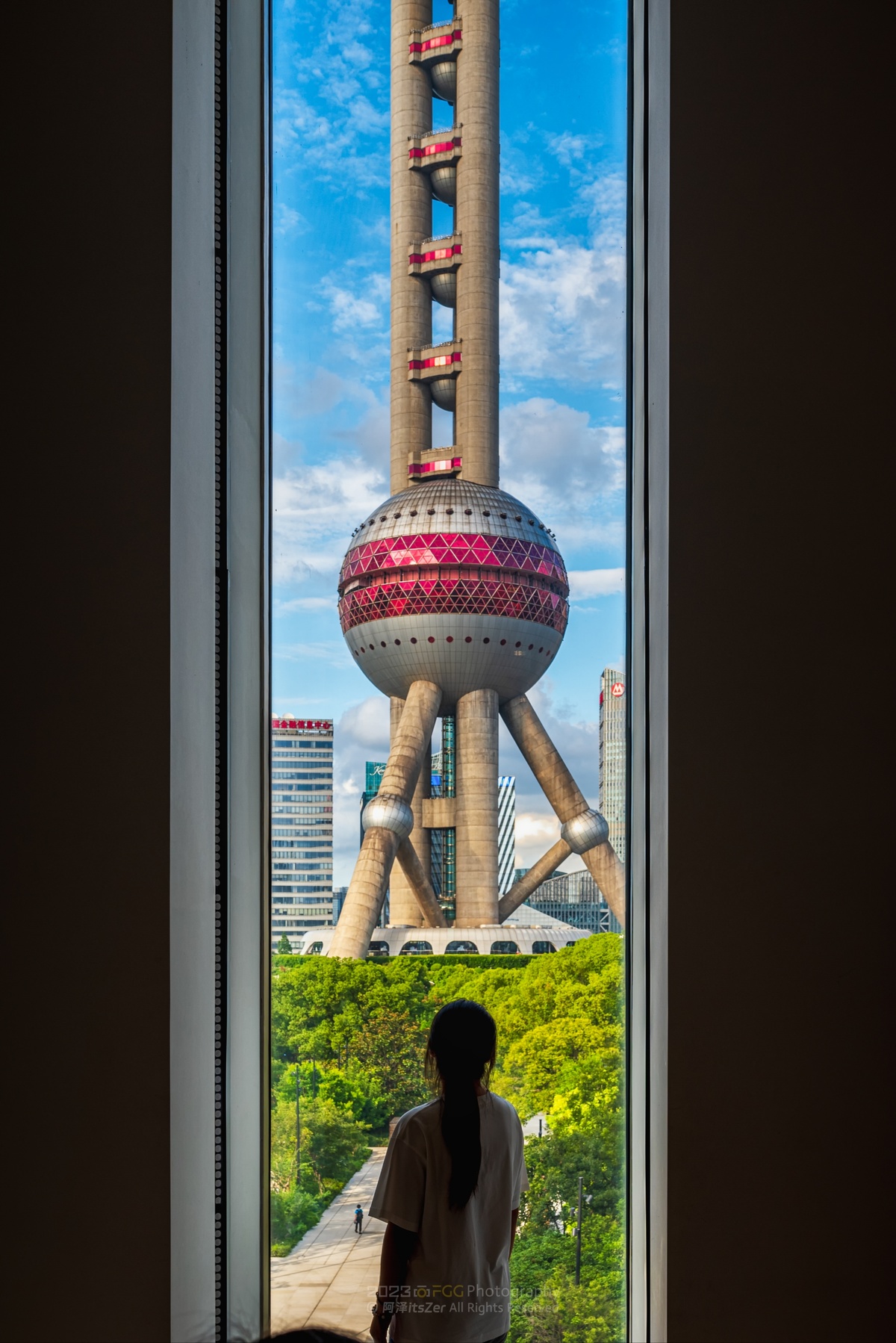 一位站在窗前向外眺望城市的女士