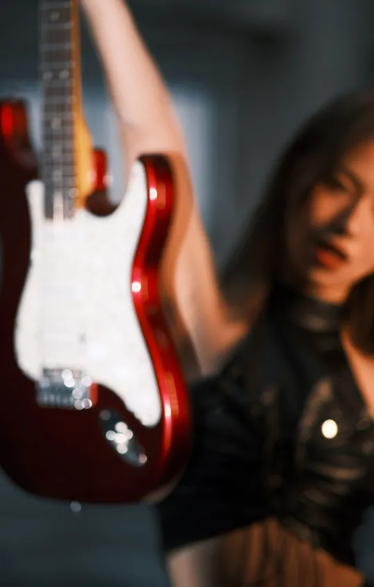 一位年轻女子正在演奏一把红色的电吉他