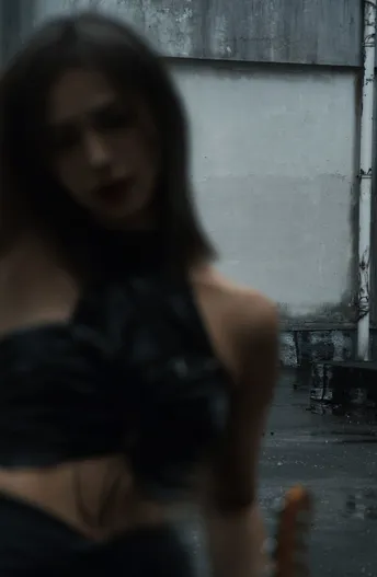 一位女士在雨中打着黑色雨伞行走