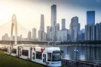 宽阔的水域 一座桥横跨其宽度 一辆白色公交车停在城市的轮廓线前草地上的景象。