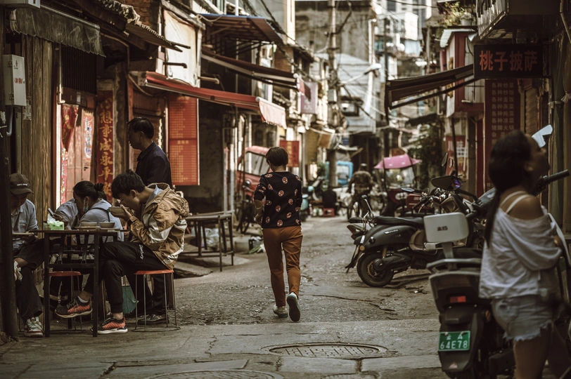 一位女士在城市的一条狭窄巷子里行走