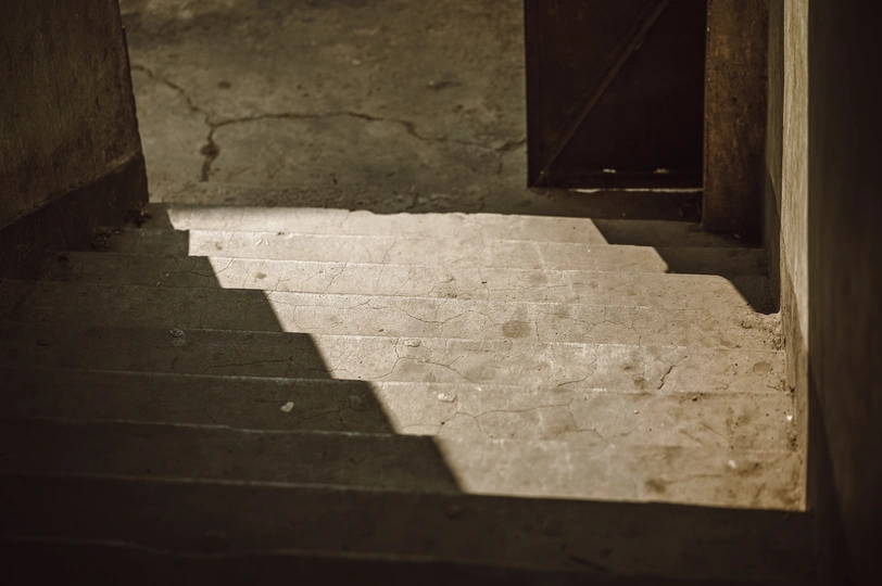 通往敞开大门的黑暗楼梯 楼梯上有光和影子的变化。