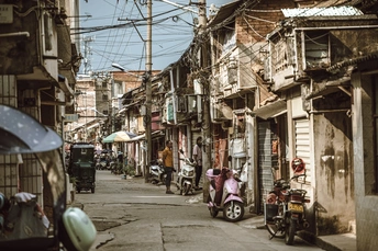 城市中的狭窄巷道 古老的建筑 人们骑着滑板车