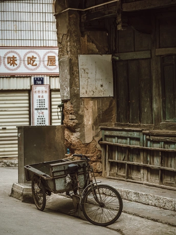停在建筑物前的旧自行车和推车