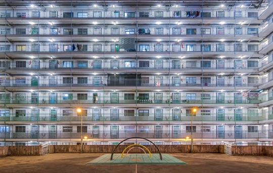 夜晚照亮的大型公寓楼带有游乐场