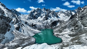 被积雪覆盖的山环绕的蓝色湖