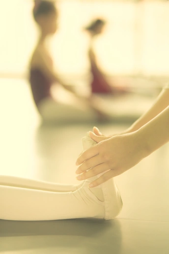 白鞋舞女郎的腿和脚在地板上