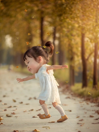 一个小女孩穿着白色裙子走在小径上