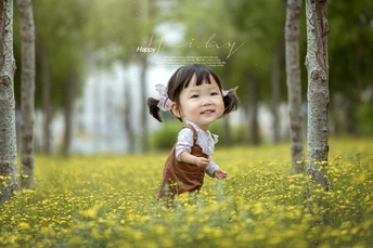 一张小女孩站在黄花草地上的照片