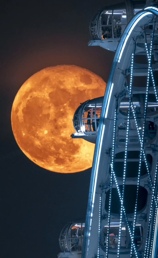 背景是满月的摩天轮