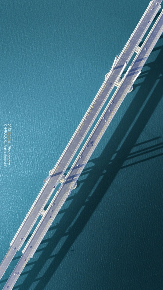 a long ladder casting a shadow on a blue wall