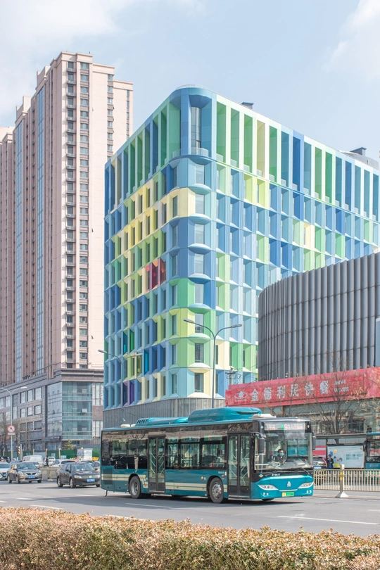 蓝色公交车驶过一排高楼旁的一条街道