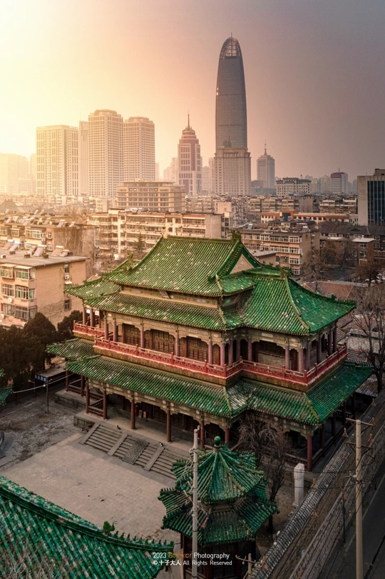 城市天际线前的一座带有绿色屋顶的寺庙