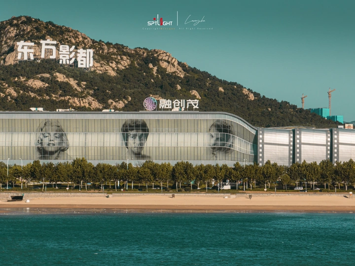 面对海滩和山脉的一座大型建筑 上面有一个脸