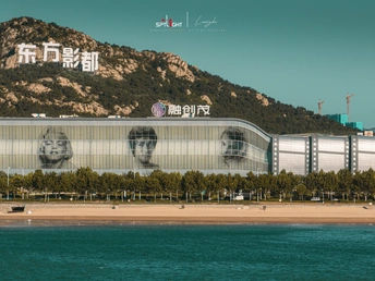 面对海滩和山脉的一座大型建筑 上面有一个脸