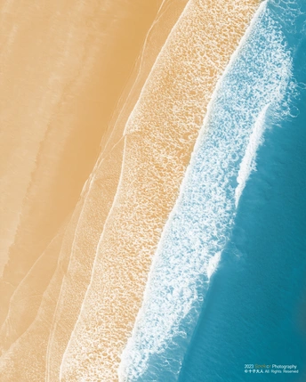 沙质海滩的 aerial view 带有蓝色水域和波浪。