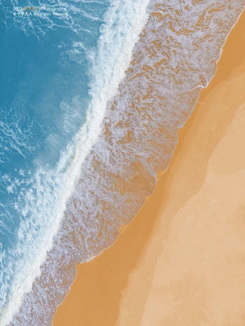 aerial view of a sandy beach and turquoise blue wa