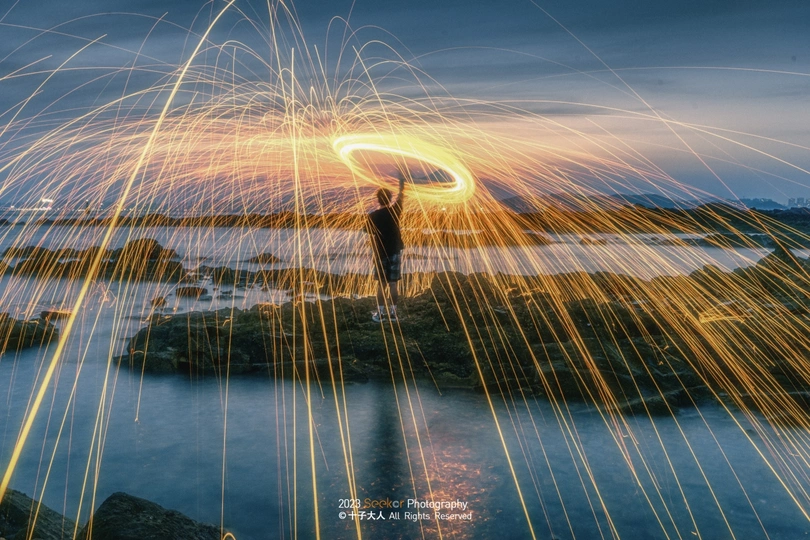 一个人站在水里 天空中有一盏灯