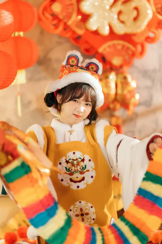 一个小女孩穿着传统服装参加节日 身上挂着彩色灯笼。