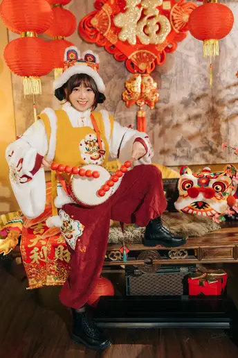 一个穿着传统服装的年轻男孩坐在长凳上