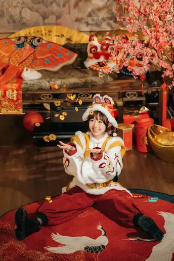 一个小女孩穿着传统服装坐在地板的边缘