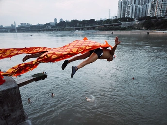 一位年轻人从河里跳入水中