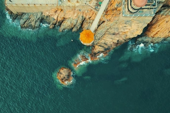 岩石海岸的空中视角 有一座灯塔屹立在悬崖上 俯瞰着海洋和岩石。