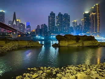 夜晚的城市 一座桥跨过水面 天际线上的摩天大楼被点亮。