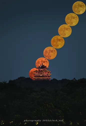 一轮满月在寺庙上空升起