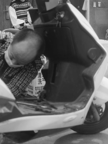 一张黑白照片 一个男子坐在滑板上。