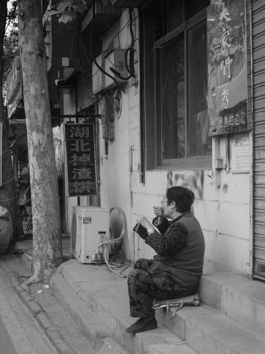 一位女性坐在建筑物台阶上 黑白照片