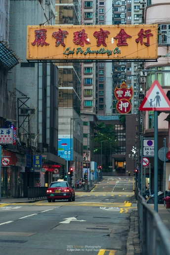 沿着高楼大厦旁边街道行驶的汽车