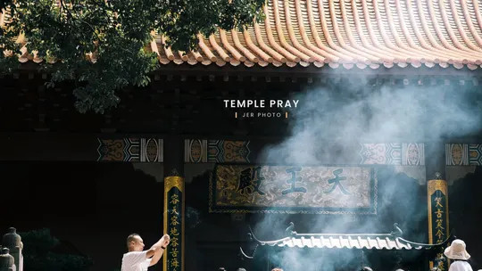 站在一栋有烟出来的建筑前的人